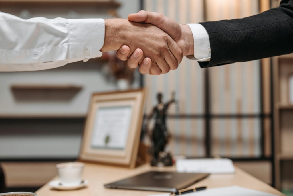In-Demand Finance Careers 2026: Where Companies Are Hiring Right Now Close-up of a handshake between two professionals in a modern office setting, emphasizing partnership and agreement.